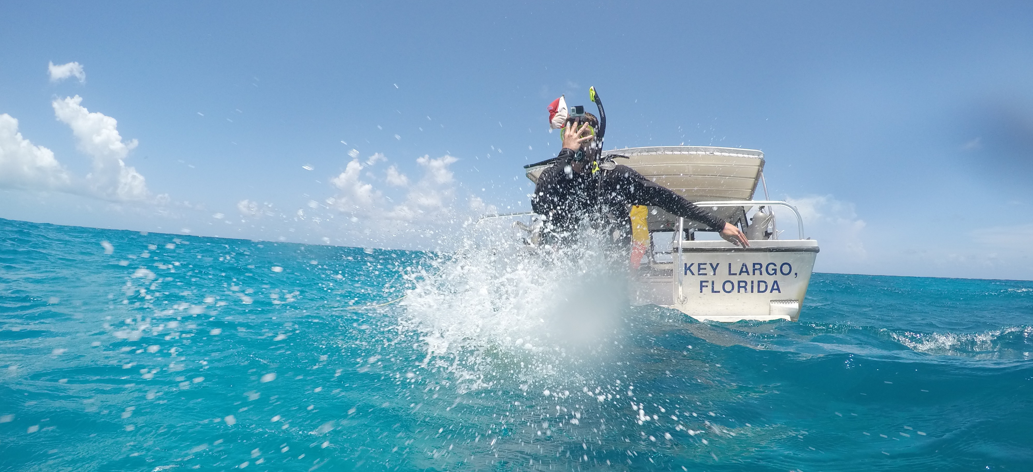 A scuba diver doing a Giant Stride to get into the ocean